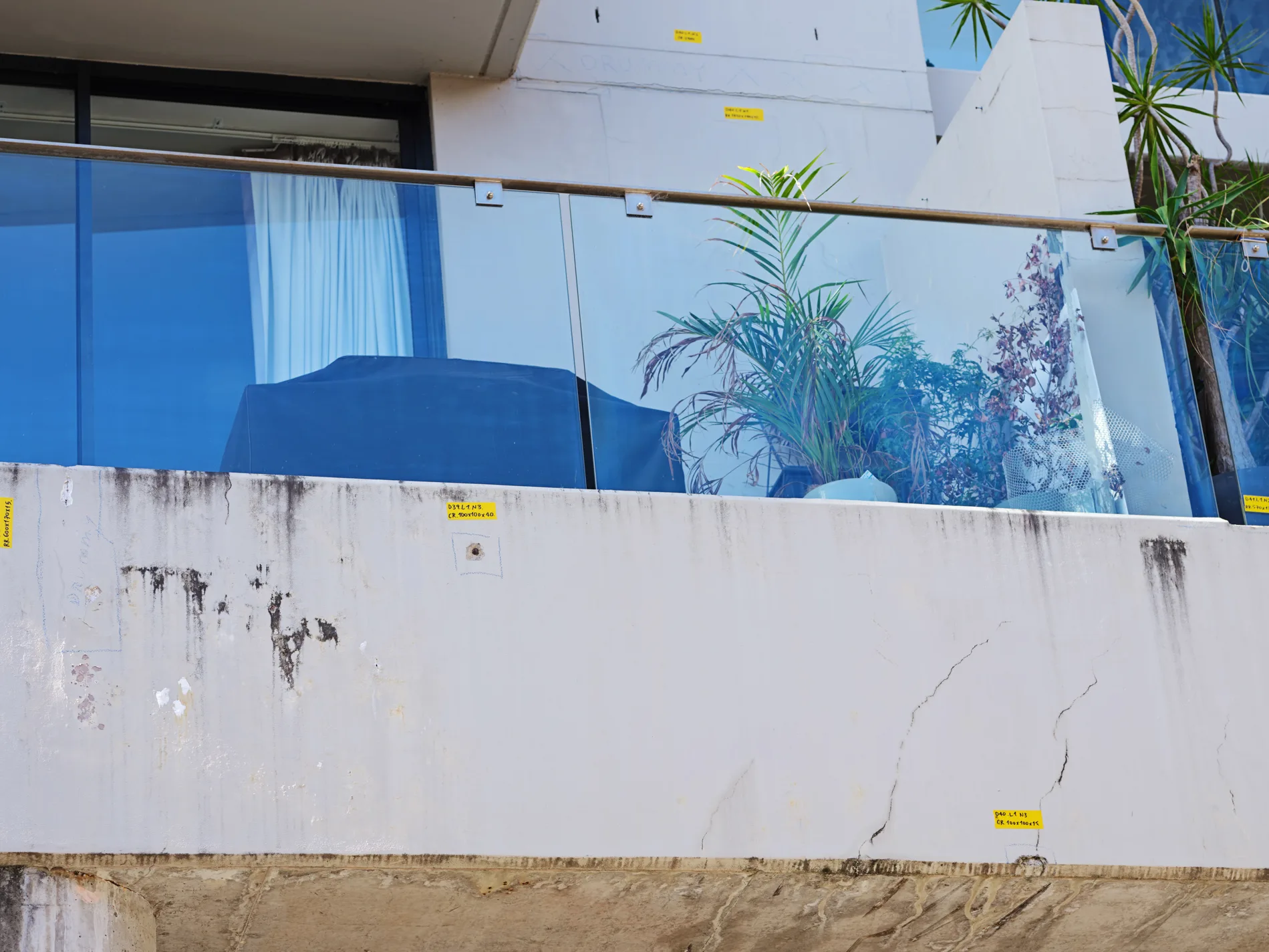 Cracking and deterioration on a painted exterior wall of a commercial building
